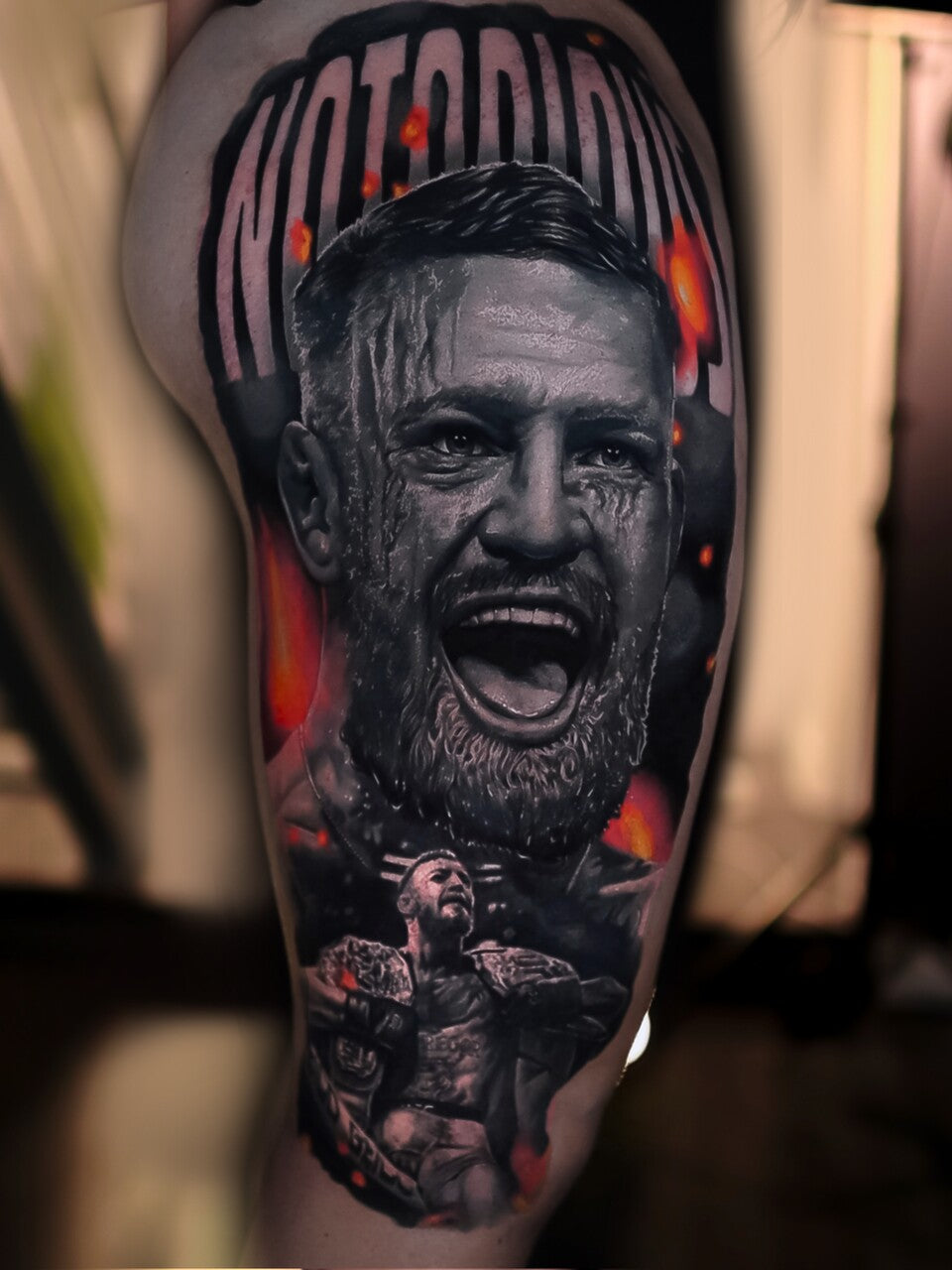 Tattoo of a man's face with 'Motörhead' text on a blurred background